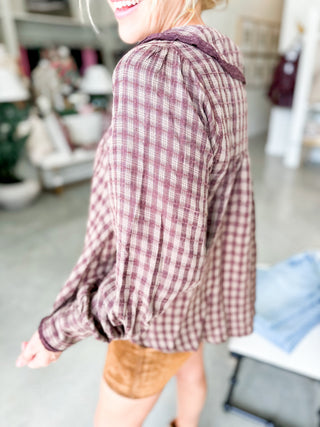 Person wearing a plaid shirt in an indoor setting